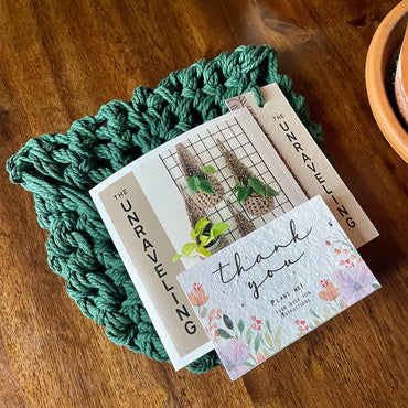 Photo showing handmade green plant hanger folded and ready for posting with handwritten note to the customer and thank you seed card.