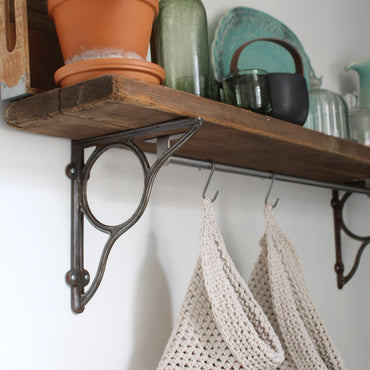 Photo showing white cotton small and large scandi storage bags in a kitchen suspended by metal hooks from a hanging shelf, the space saving storage bags are filled with fruits and vegetables