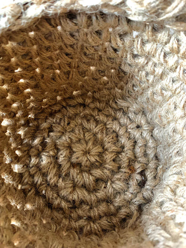 Photo showing close up interior view of standing jute plant basket. Demonstrates the crocheted texture and the construction of the basket.