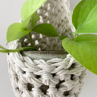 mage showing close up crochet details of tierdrop shape white cotton plant hanger, containing pot and plant. To give an idea of how the planter would look in situ and the woven texture of the fibres.