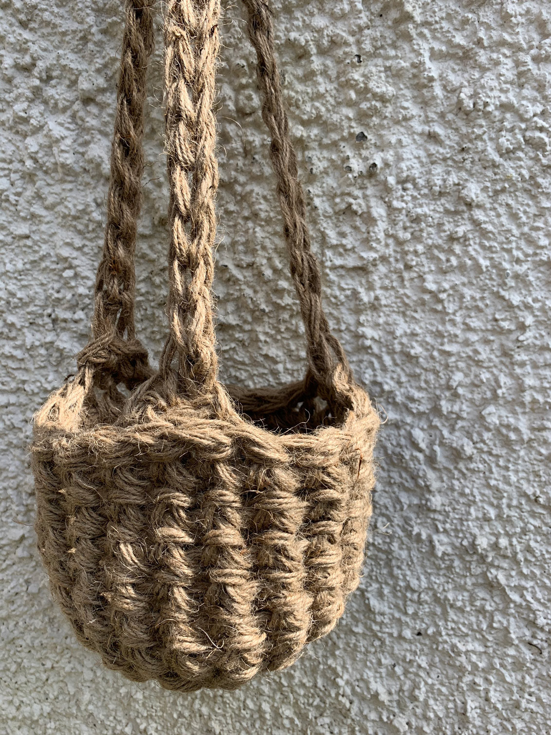 Photo showing the natural jute hanging plant holder without ceramic pot or plant. Designed to demonstrate the shape of thew lower part of the basket on it's own.