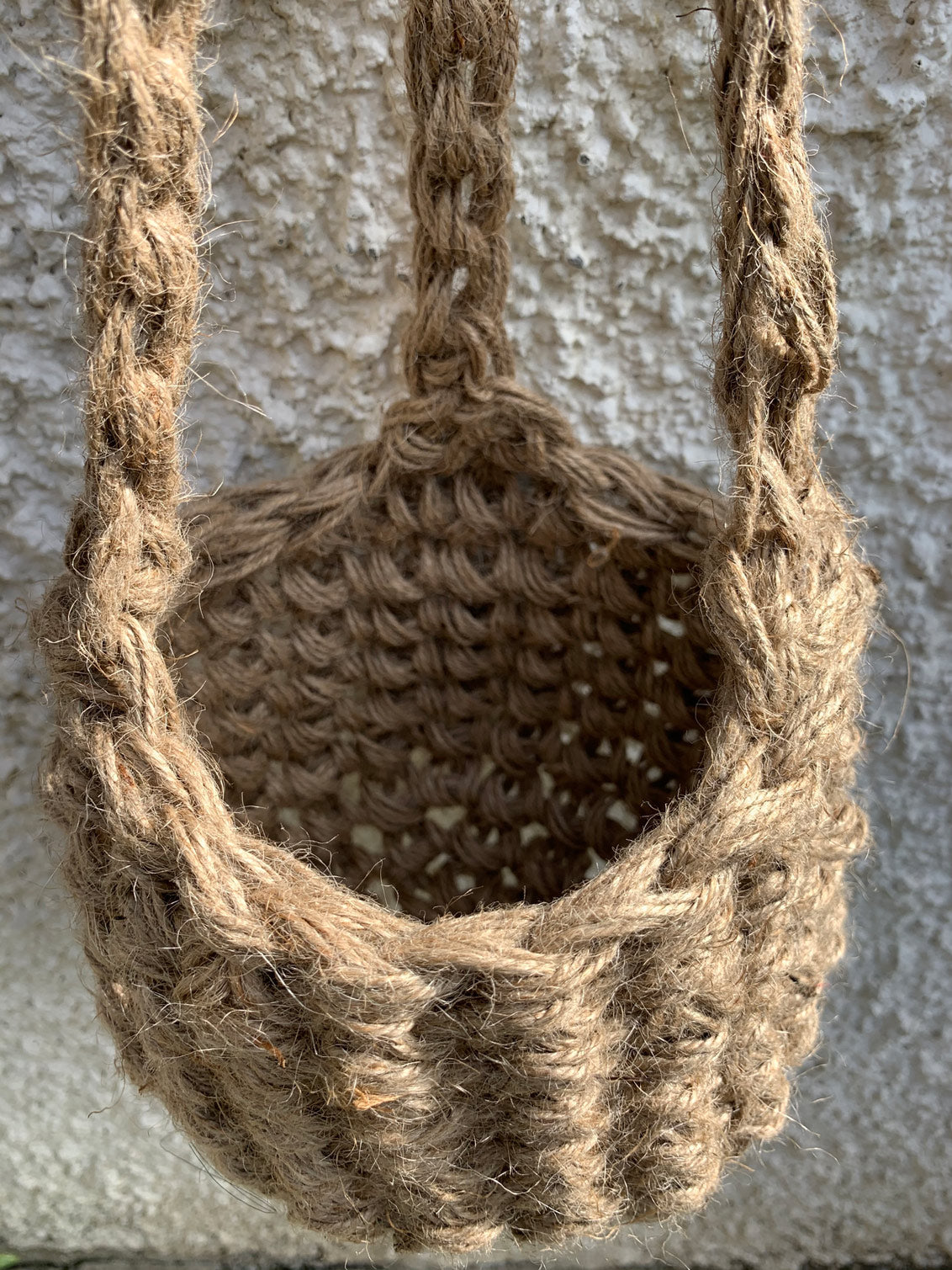 Photo showing the natural jute hanging plant holder without ceramic pot or plant. Designed to demonstrate the shape of thew lower part of the basket on it's own.