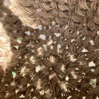 Close up photograph of the interior jute hanging basket, without pot or plant. Photo shows the pot like shape of the handmade crocheted basket and the woven texture of the fibres. Also shows how the basket is constructed, in the round.